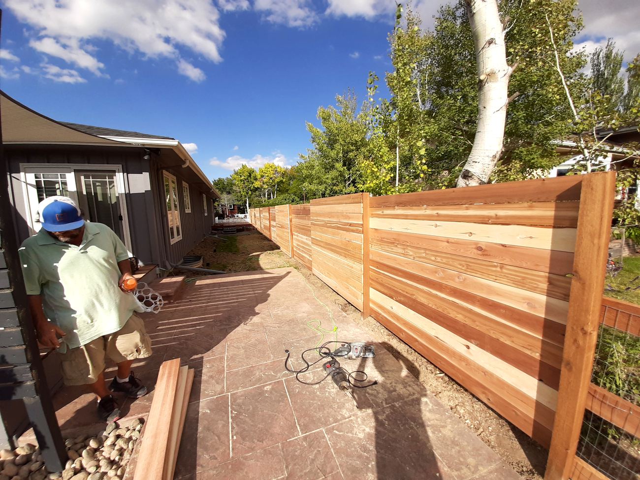 A Local Fence crew member on site during a horizontal cedar fence installation